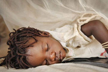 Ein afrikanisches kleines Mädchen schläft unter einem Moskitonetz. Foto: ifrc